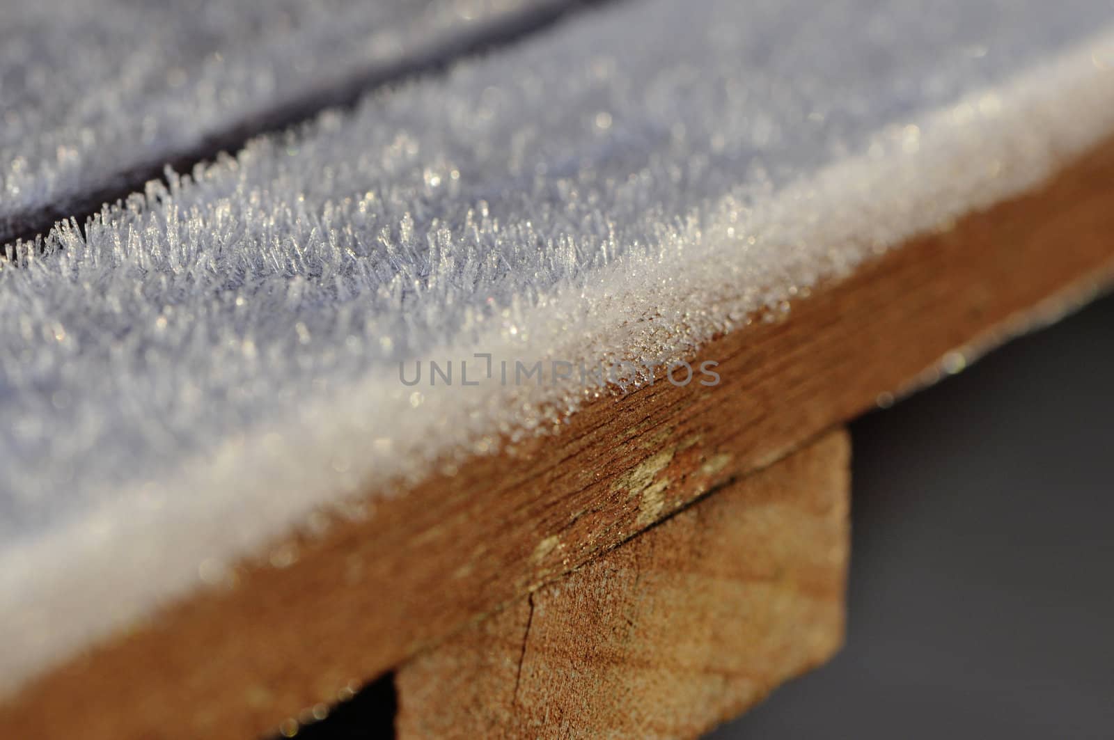 Frost on brown wood table with a thin dept of field