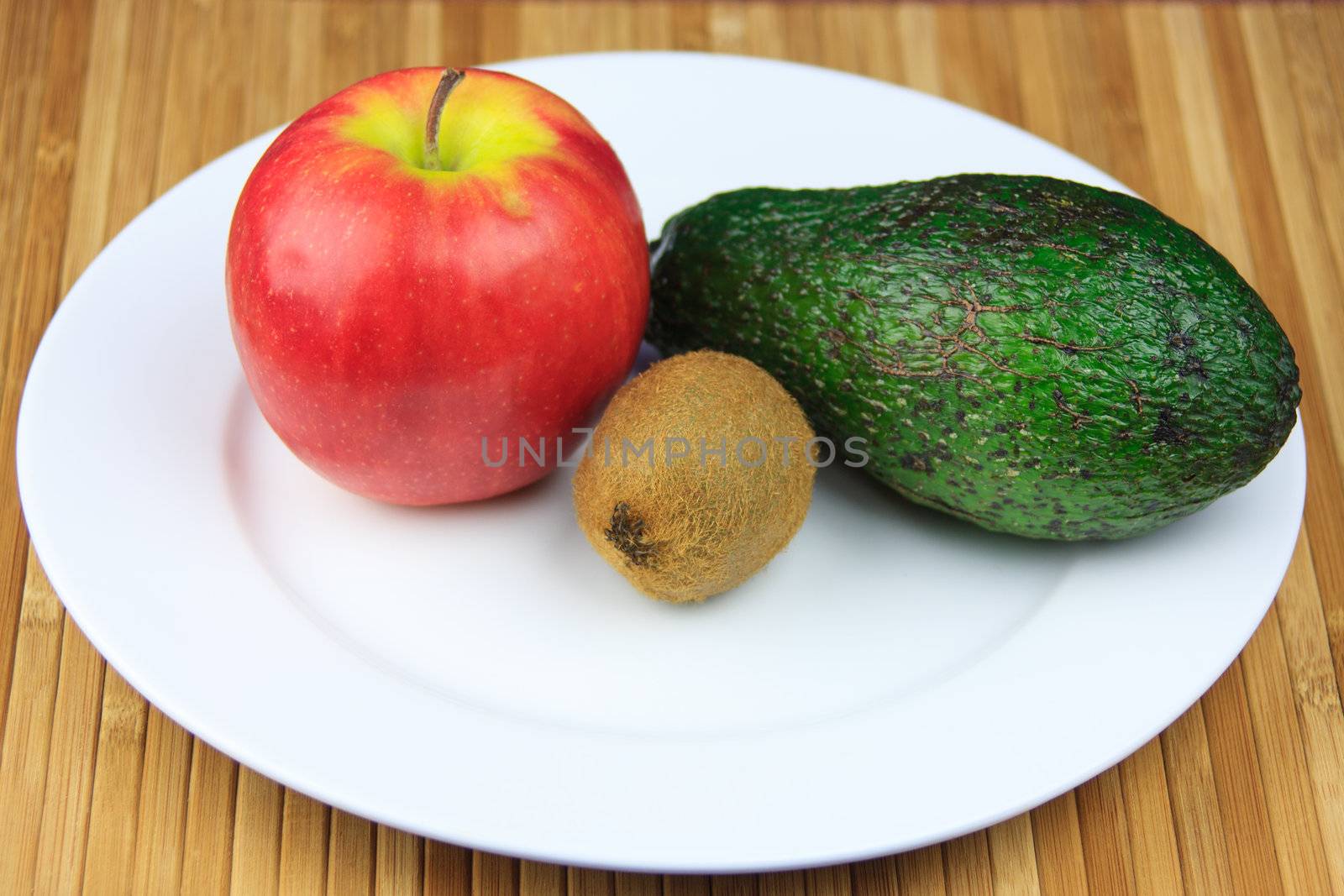 apple, kiwi and avocado on a white bowl