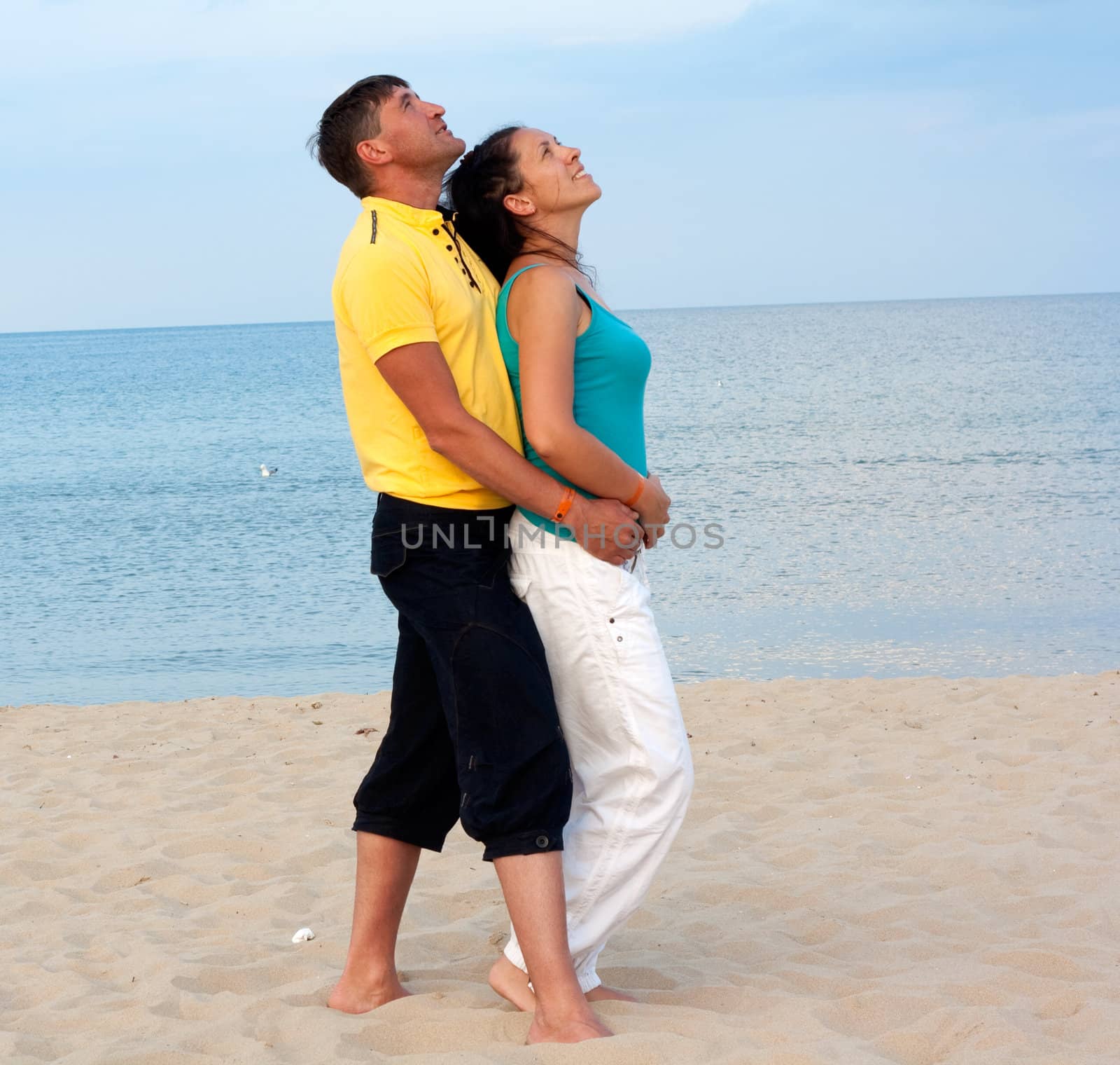 Loving couple having fun on the beach, enjoying their summer holiday together.
