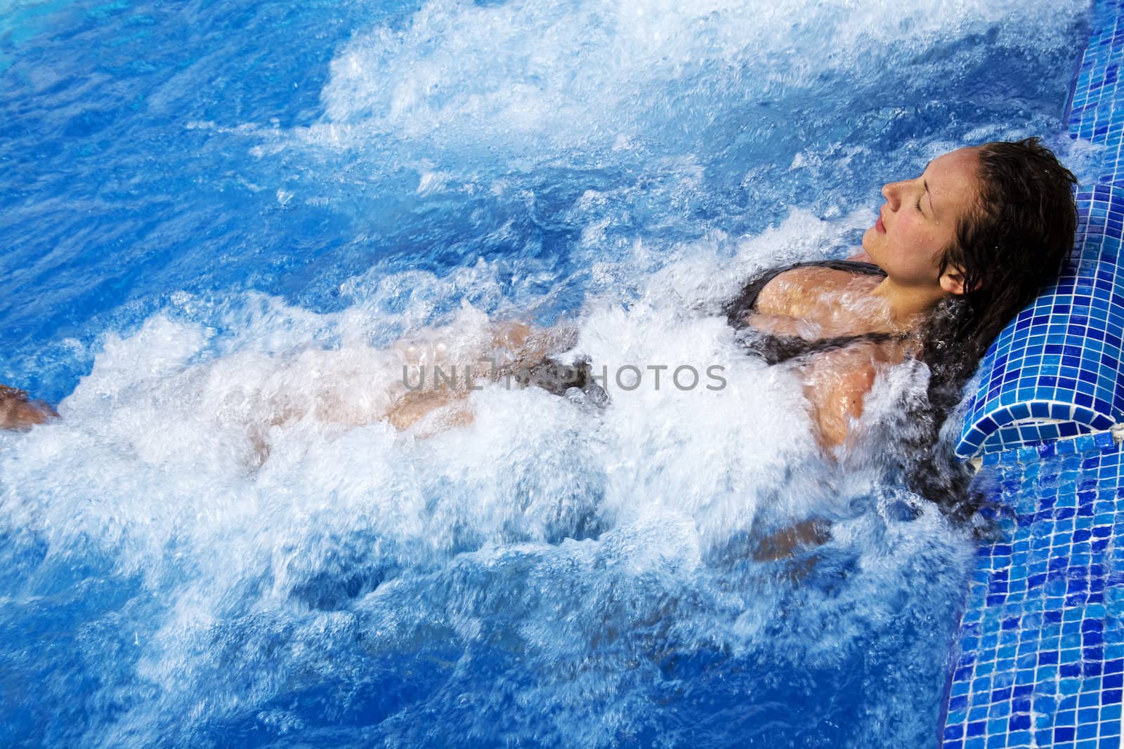 Girl lying in a pool with jacuzzi