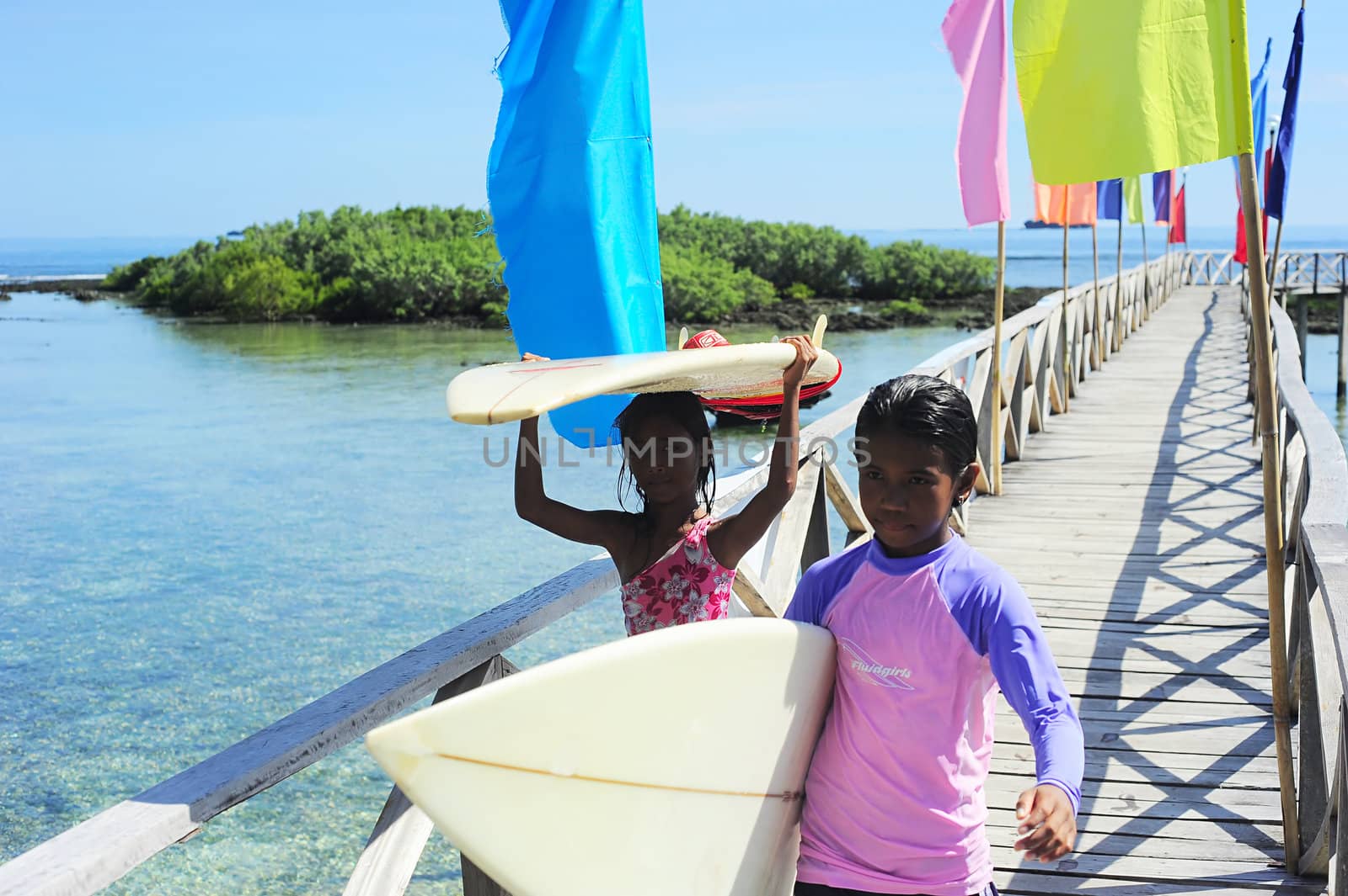 Siargao, Philippines - May 07, 2012: Two young surfers carrying surfboards at Cloud Nine surf point. Cloud Nine is the most famous surf point in Philippines.