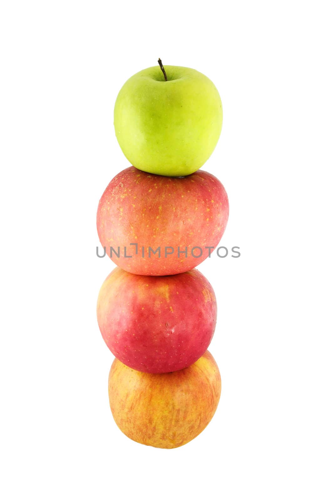 Fresh red apples stacked on top of one another with a green apple on top