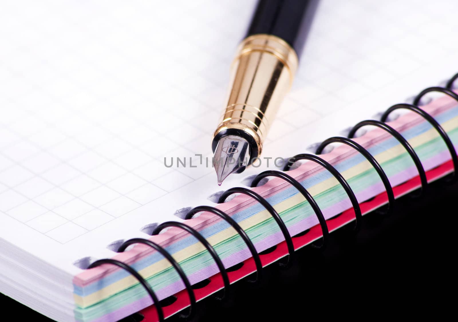 notebook and pen isolated in black bakground