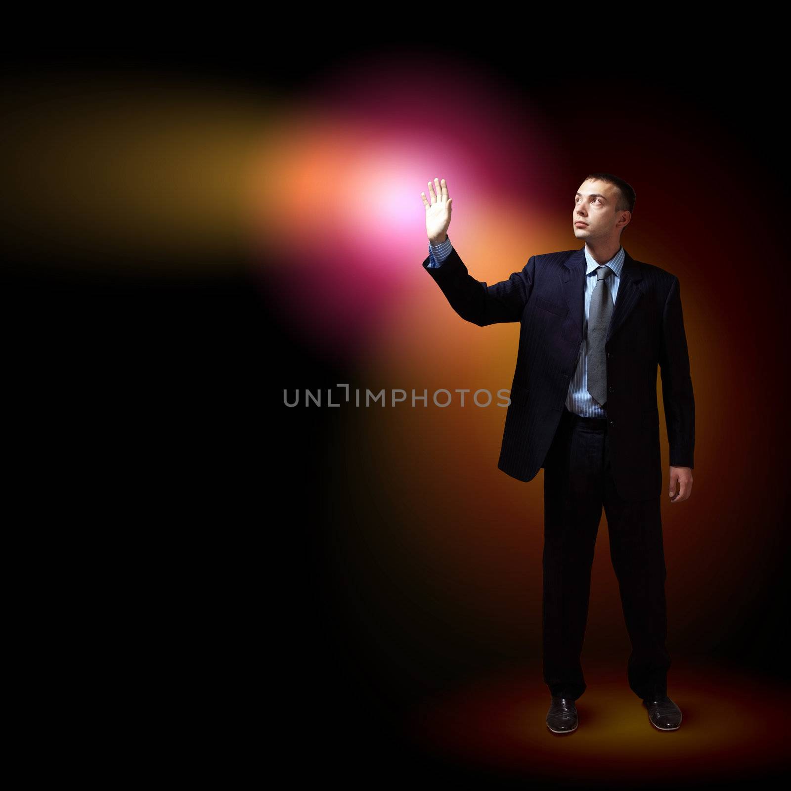 Young successful businessman holding a shining light in his hand as a symbol of success and advancement.