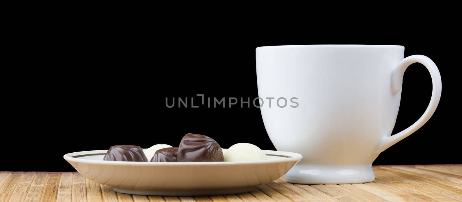 cup and saucer sweet candy isolated on black background