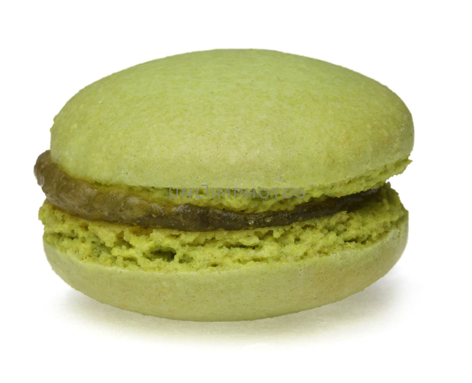 Macro image of a green macaron on a white surface.
