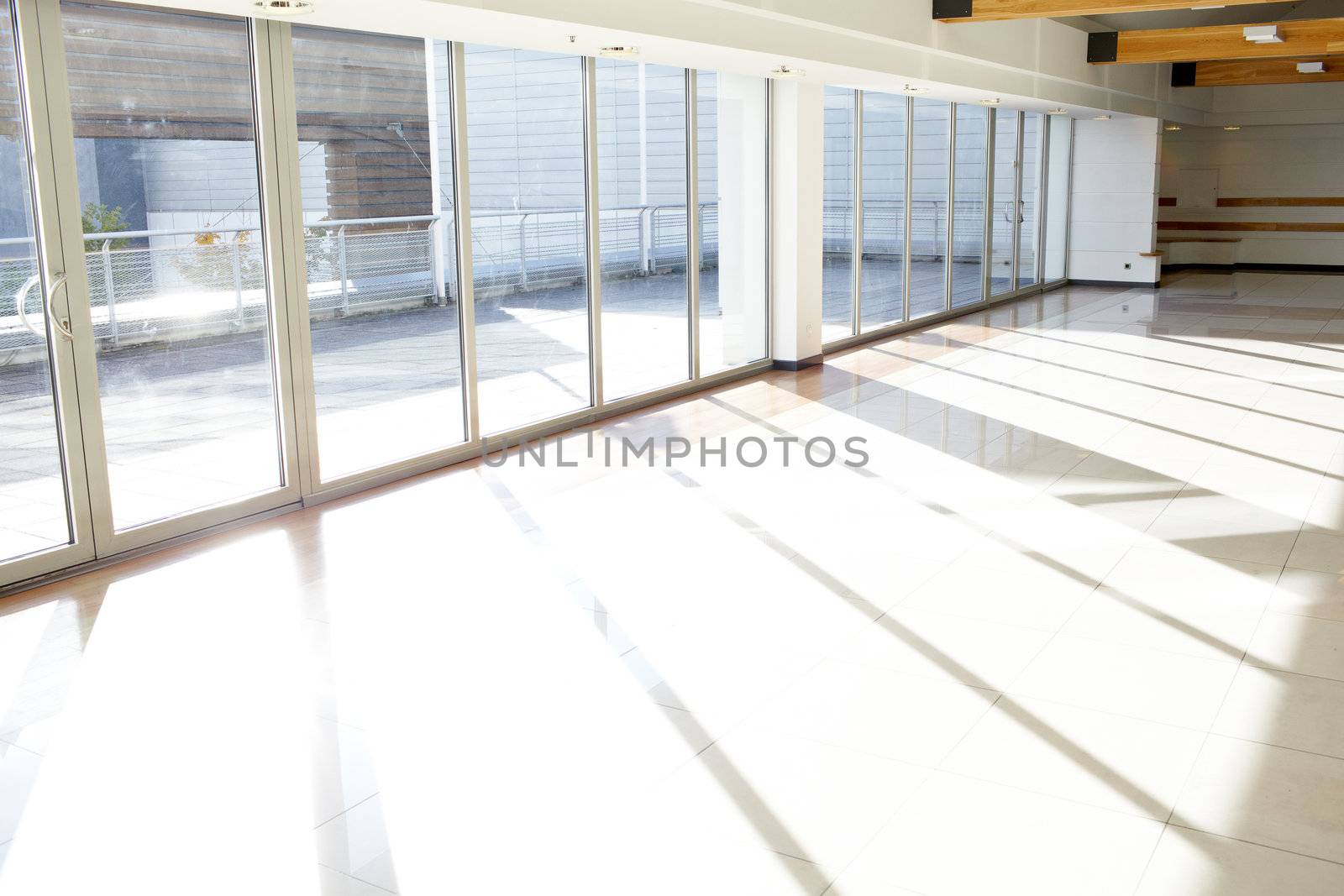 Empty corridor in office building with big windows passing daylight