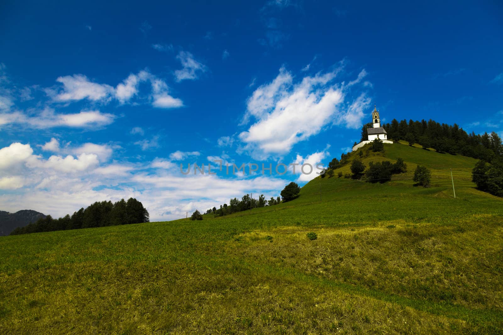 white clouds in blue sky and a little church in mountain