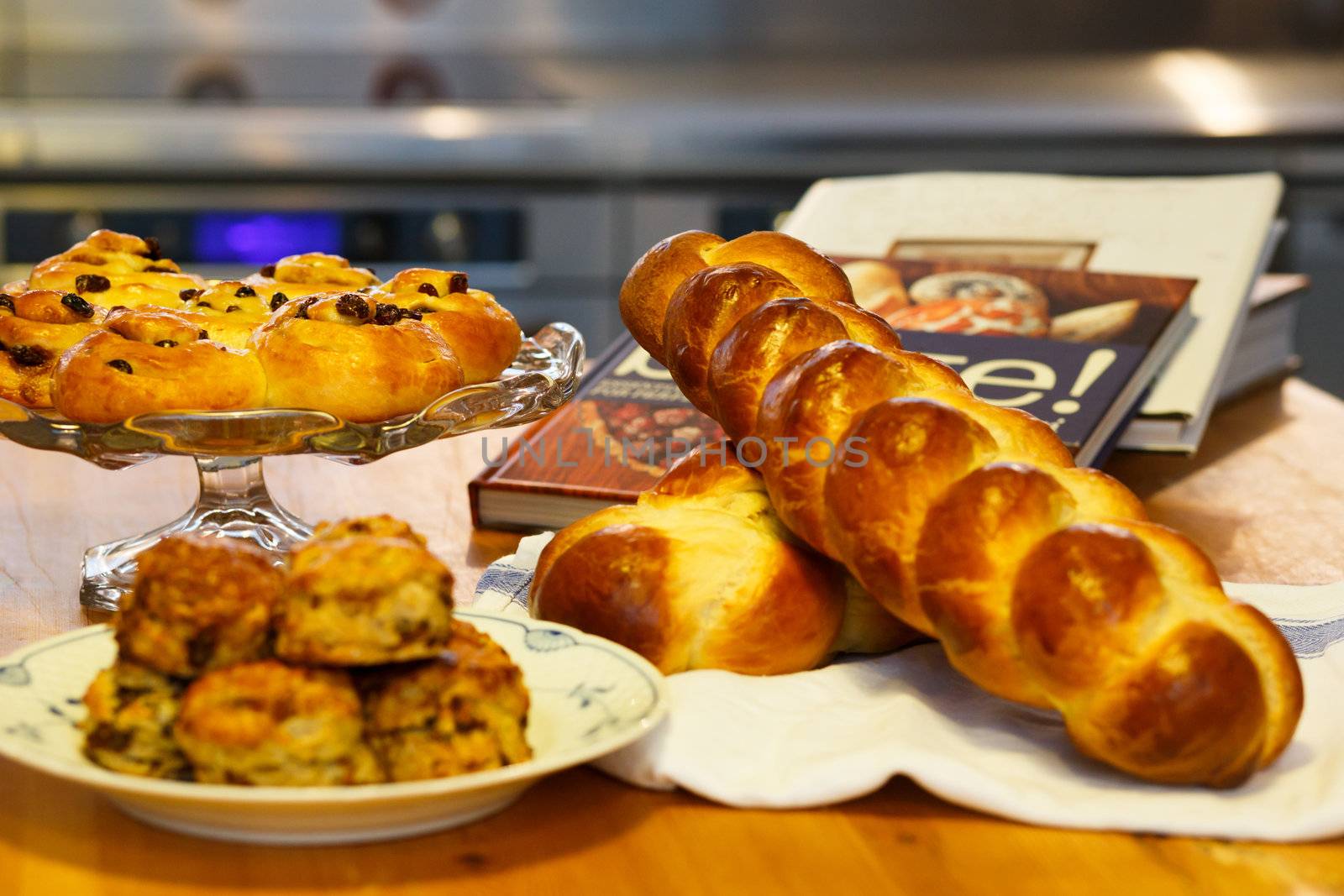 Mouth watering assortment of bakery items neatly arranged along with recipe books.