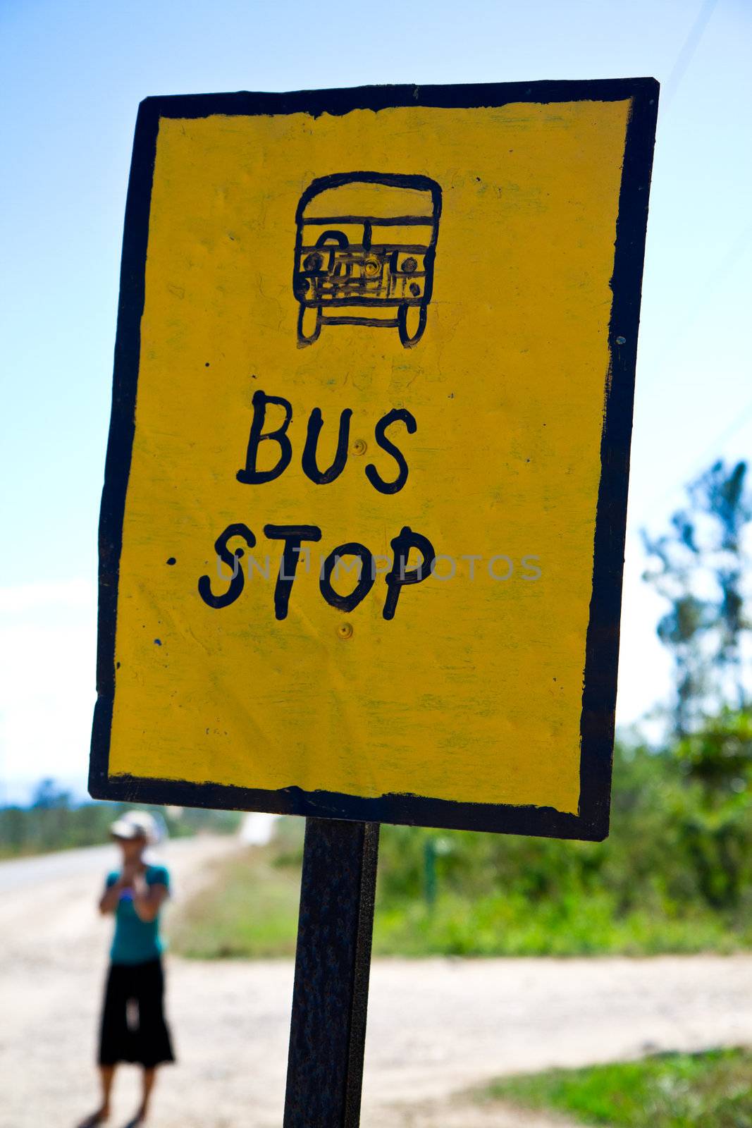 A woman waits at a home made bus stop in Belieze.