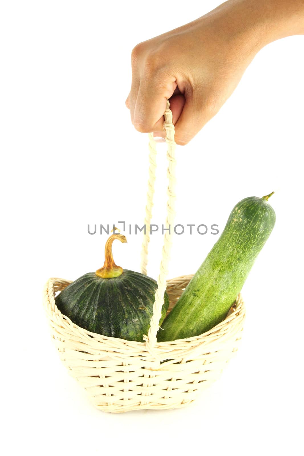 Cucumber and Pumpkin in wicker basket with hand hold by geargodz