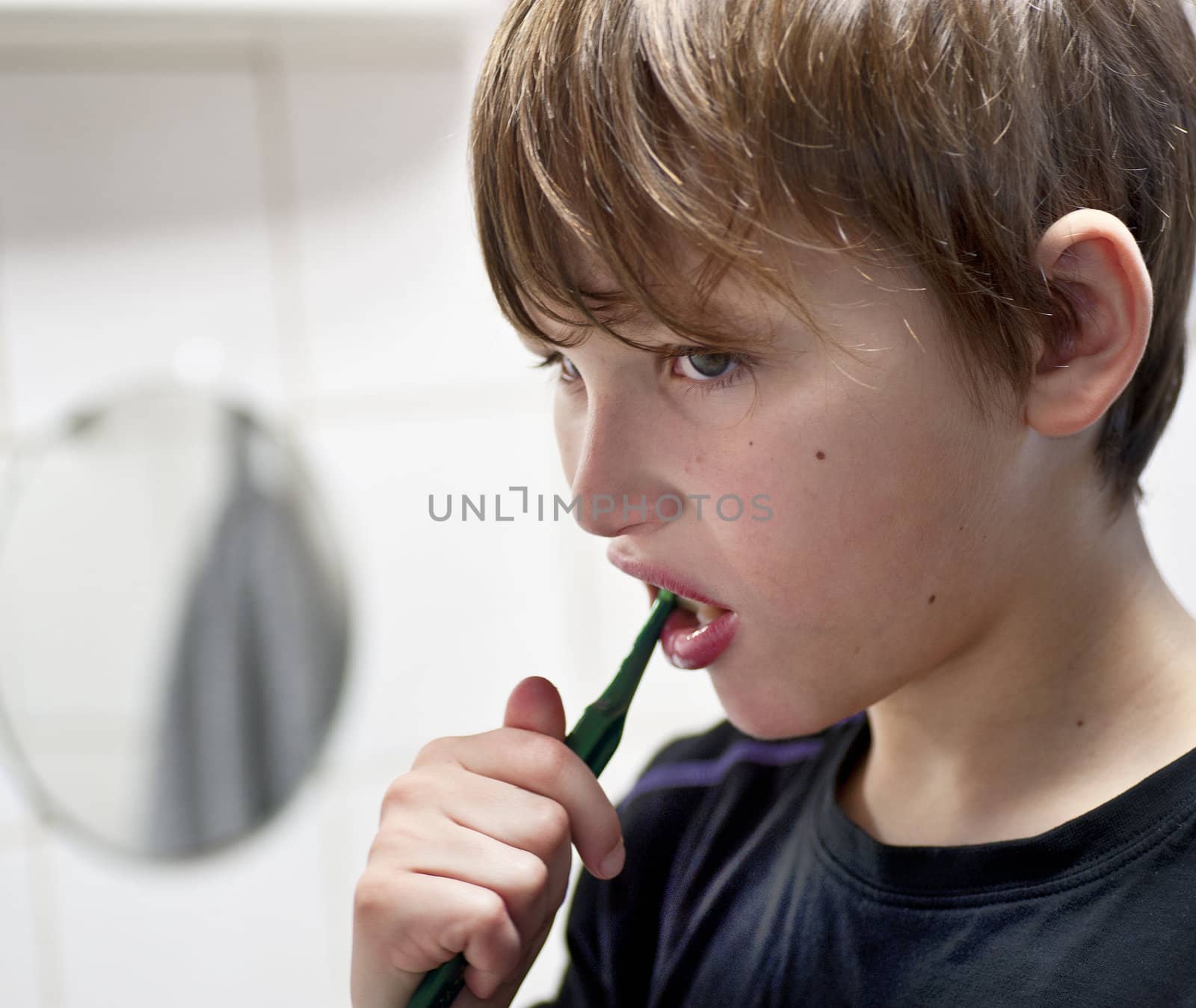 Young boy in domestic bathroom brushing his teeth 
