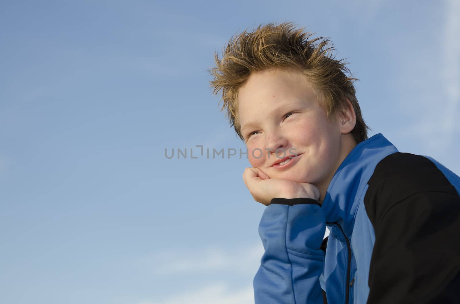 Pleased teen with spiky hairstyle against blue sky background