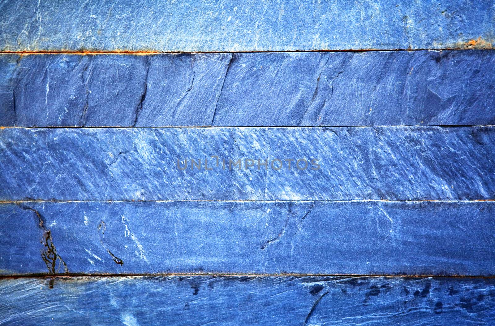 Close up of a blue brick-wall, texture background. Pattern of cracked real stone wall surface with cement