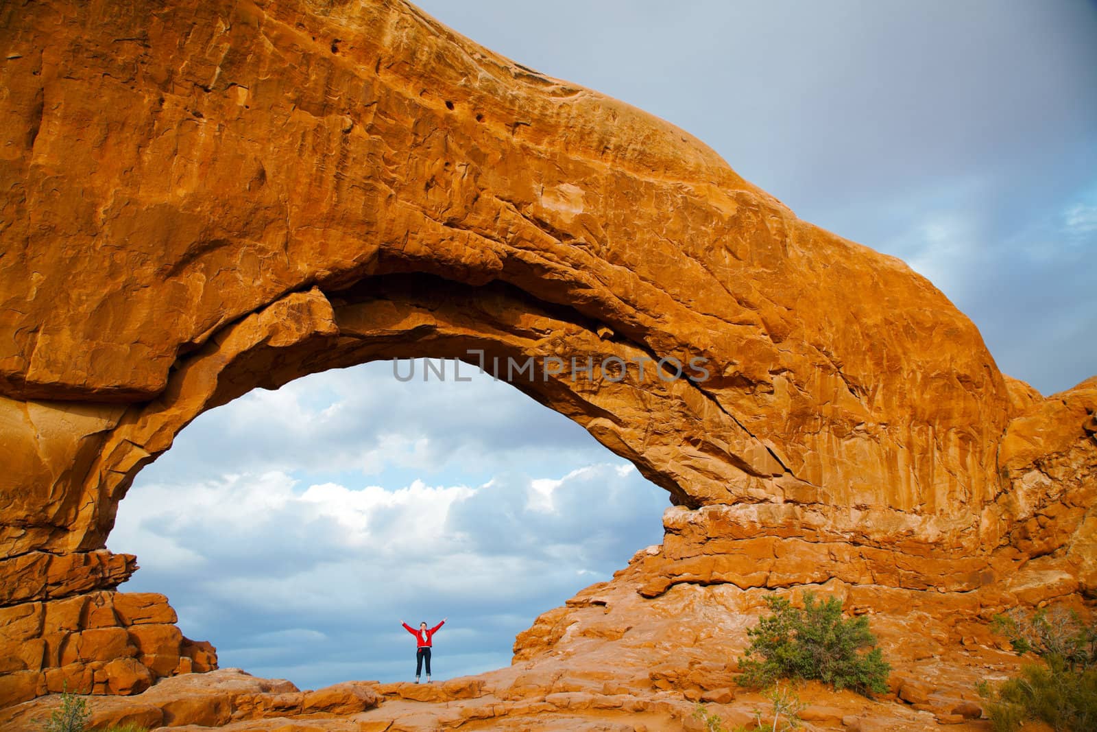 Woman staying with raised hands inside an Arch by AndreyKr
