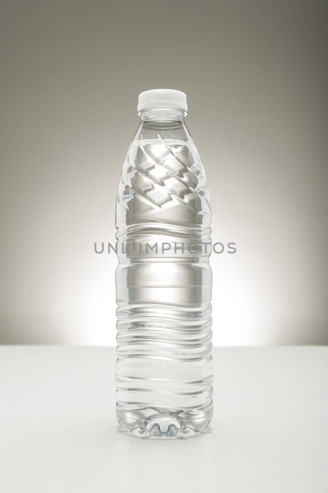 Unlabeled transparent bottle full of pure fresh water, a healthy refreshing drink to quench a thirst and rehydrate the body