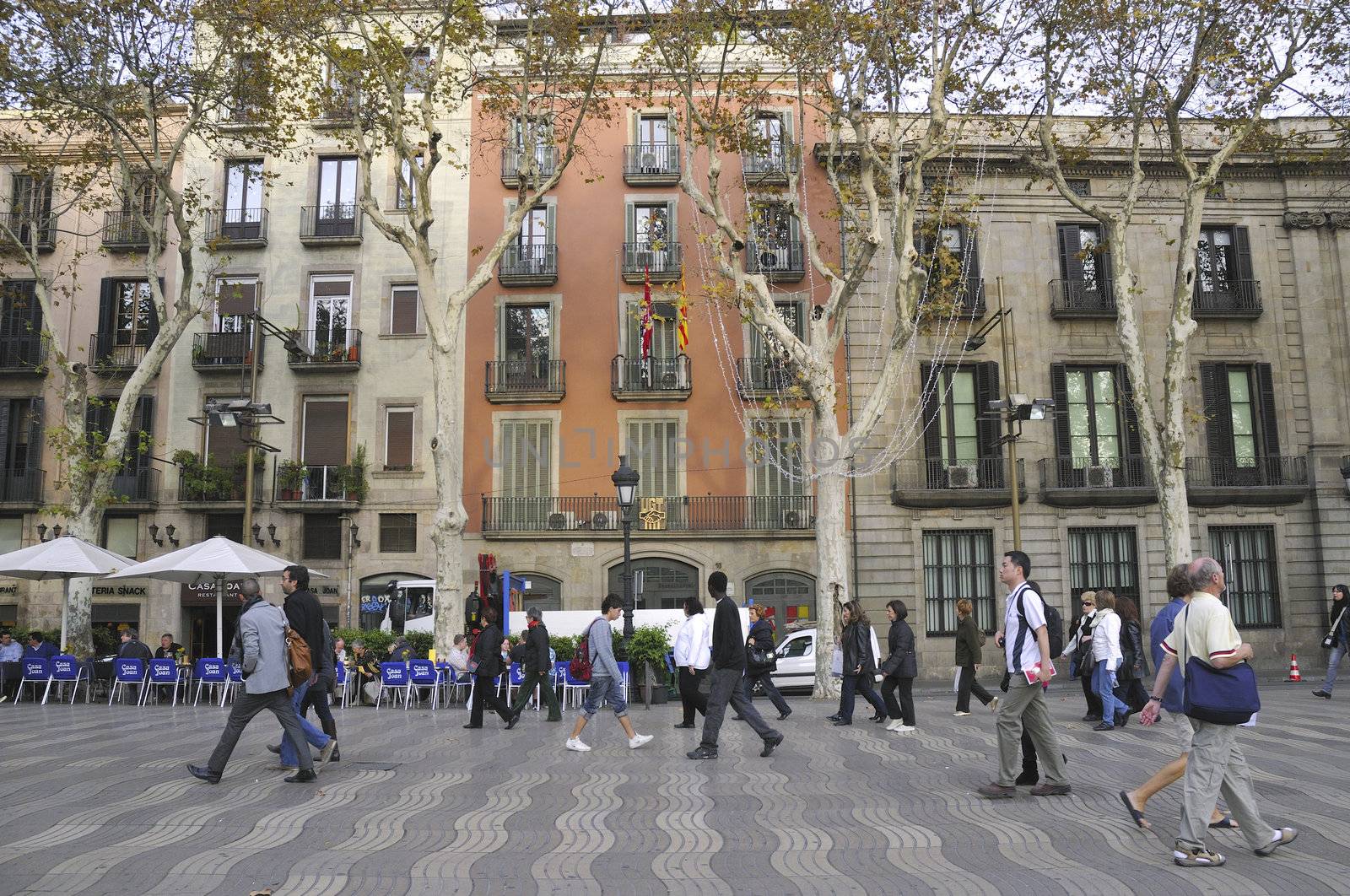 Barcelona, Spain - November 13, 2009 : people walk on wide pedestrian pathway of famous La Rambla street in Barcelona.
