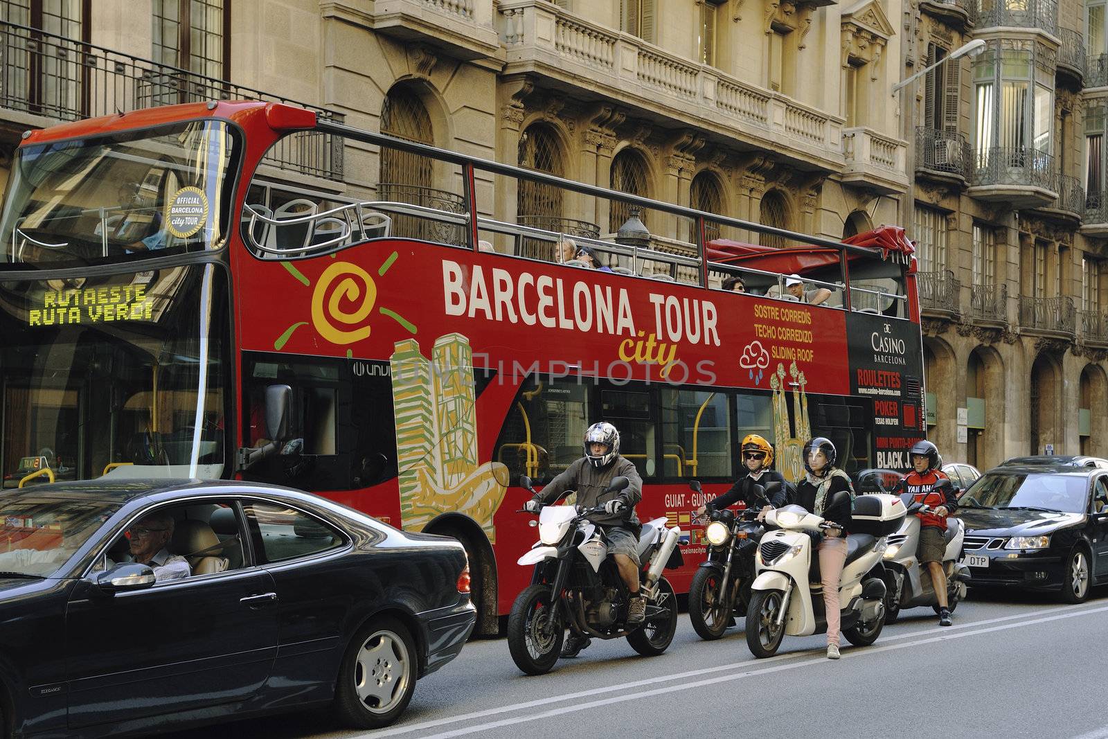 Barcelona, Spain -June 21, 2010 : big red bus with Barcelona city tour service on the Via Laietana street between cars and motorbikes.