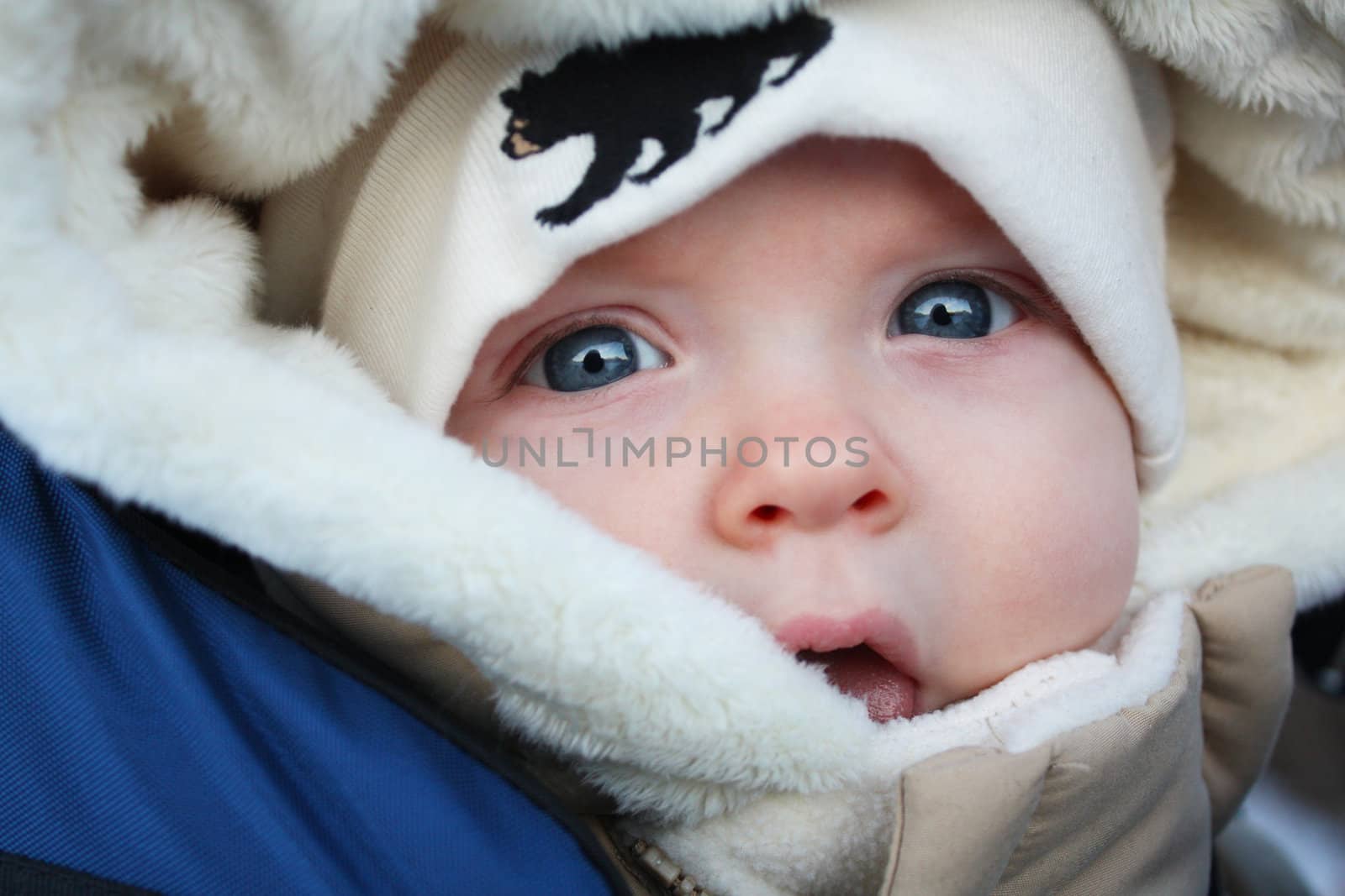 A close up image of a baby in a parka and a tuque