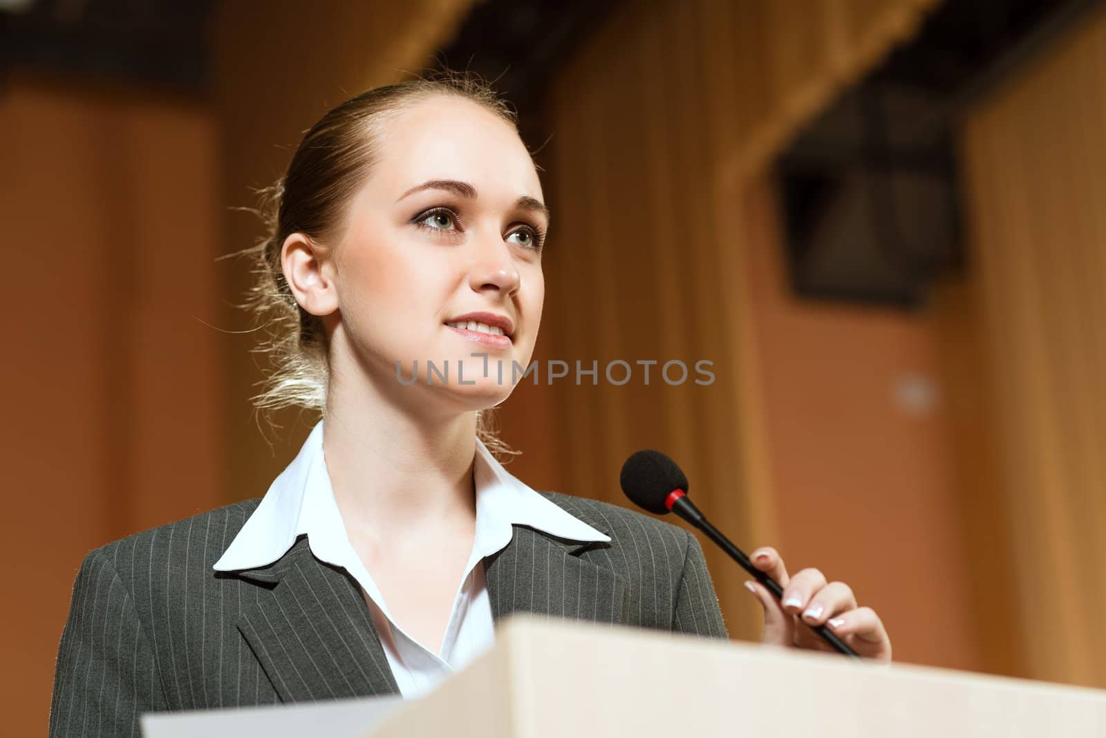 Business woman speaks into a microphone, communication businessmen at a conference