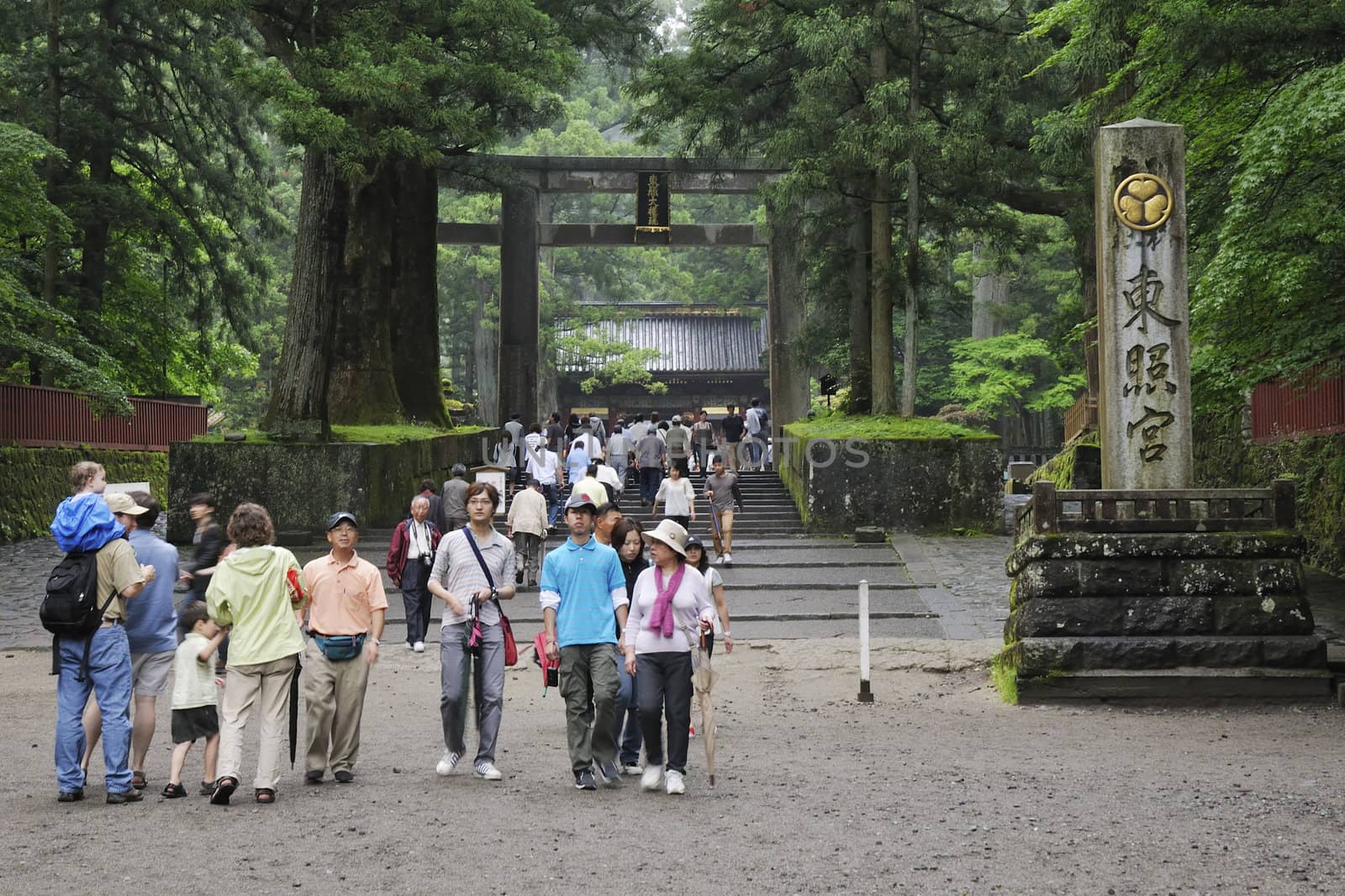 Nikko, Japan - June 22, 2008: Tourists walk at Toshogu shrine entrance by rainy summer time. Toshogu is  World Heritage site and contains five structures that are National Japanese Treasures. It is famous as a mausoleum site of Tokugawa Ieyasu, founder of the Tokugawa shogunate, which ruled Japan for over 250 years until 1868.