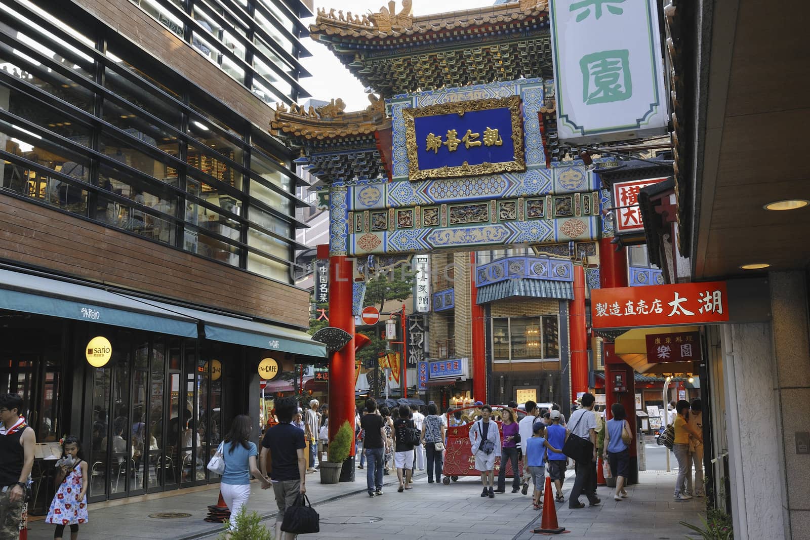 Yokohama, Japan -August 3, 2008:  people walking under main entrance gate of famous Chinatown district in Yokohama. This area is pedestrian street with many shops and restaurants.