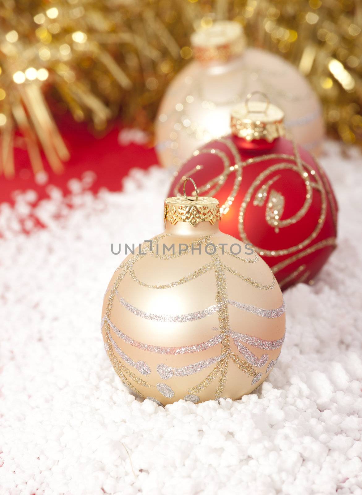 Red and gold Christmas baubles on golden background