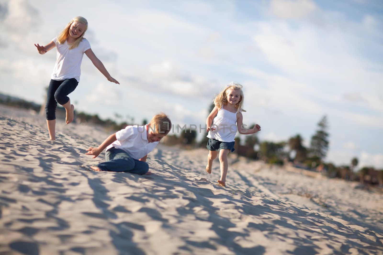 Adorable Brother and Sisters Having Fun at the Beach one Afternoon.