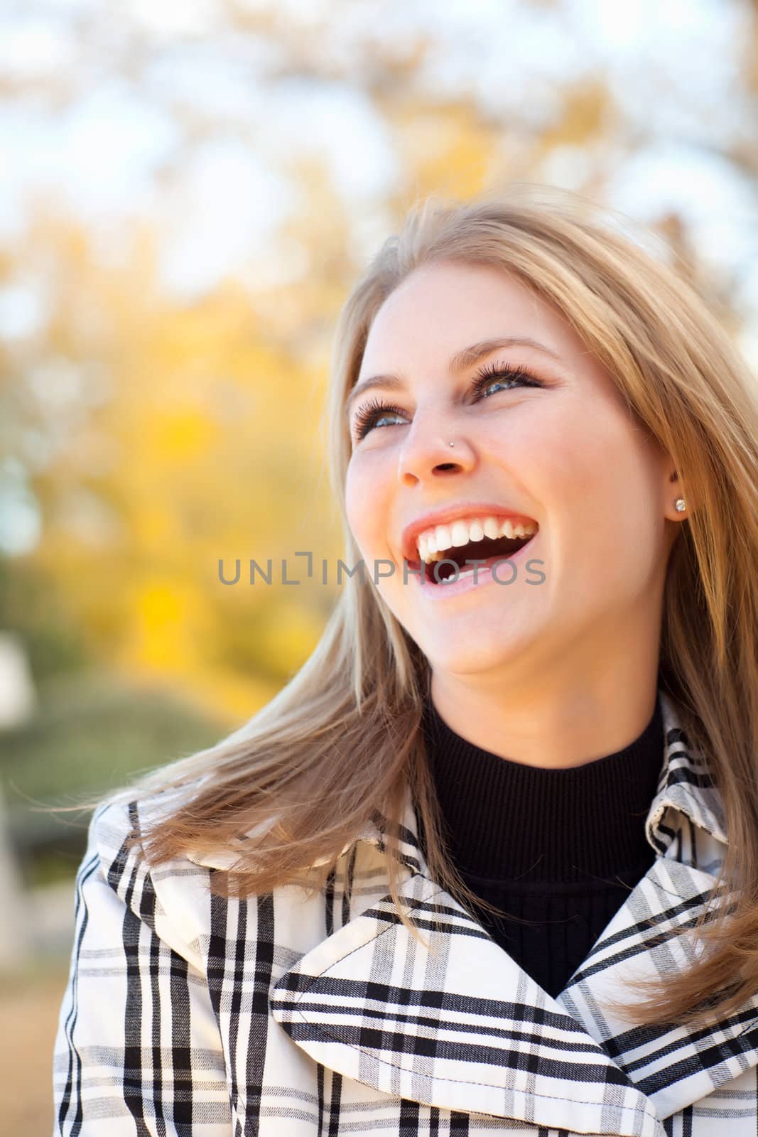 Pretty Young Woman Smiling in the Park on a Fall Day.