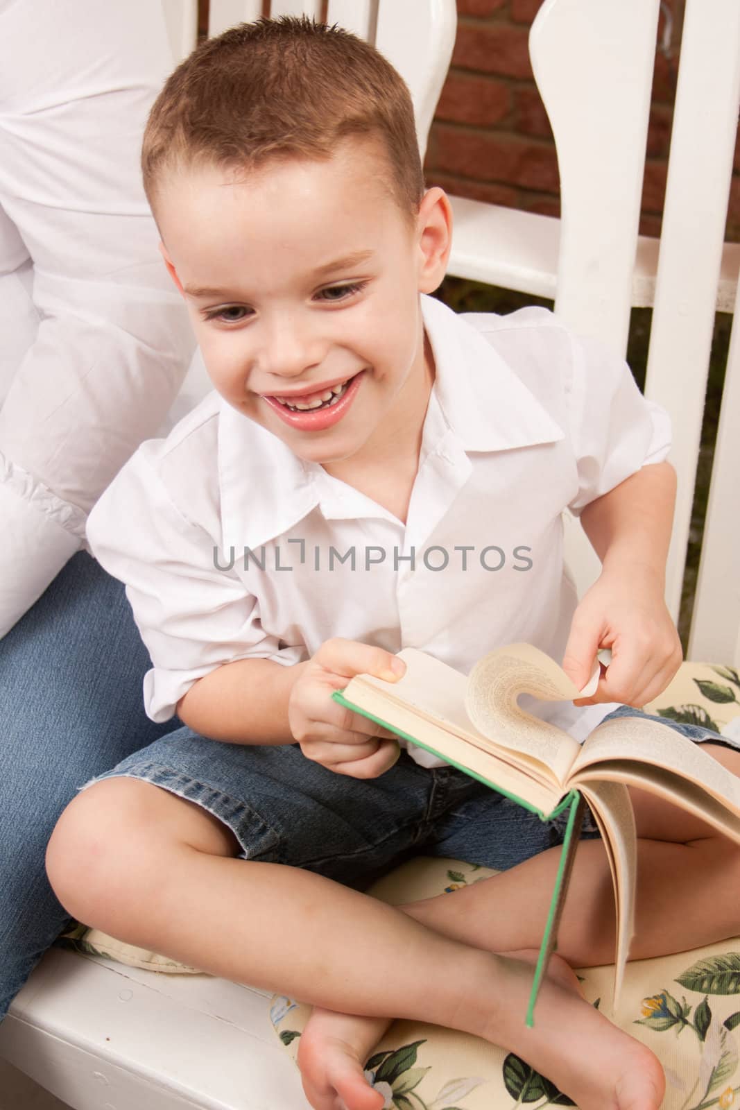 Cute Young Boy Reading His Book Indoors Next to His Mom.