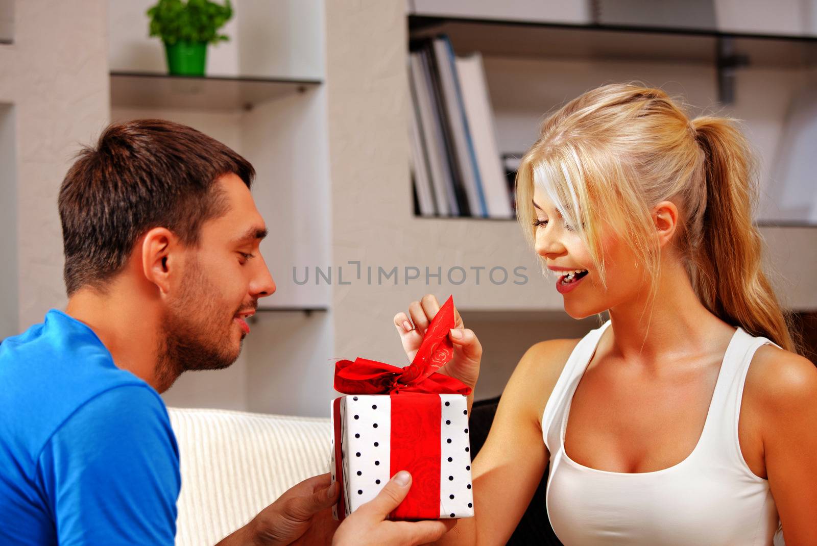 happy romantic couple with gift by dolgachov