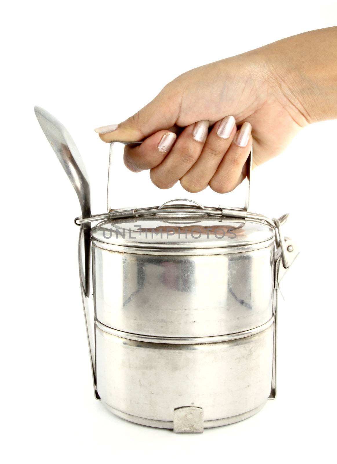 A hand holding silver metal tiffin and spoon, food container on white background