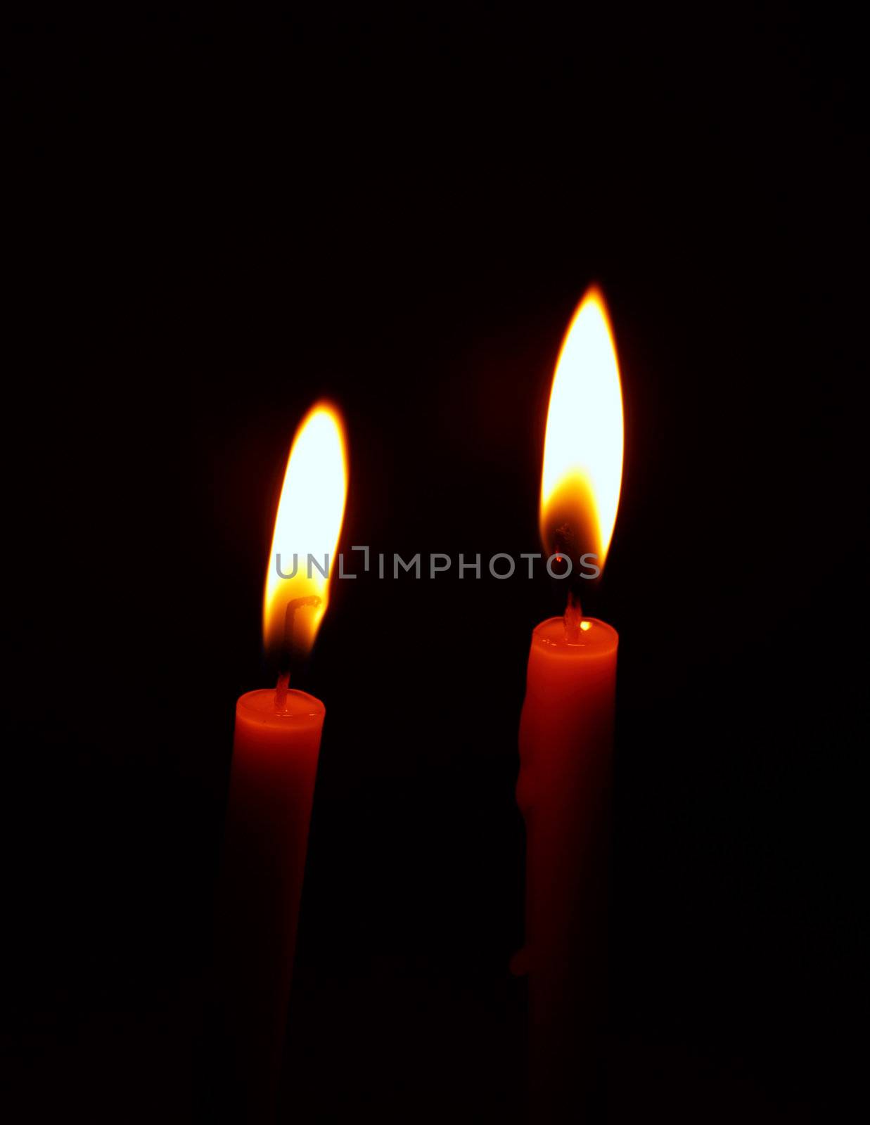 burning candle on black background