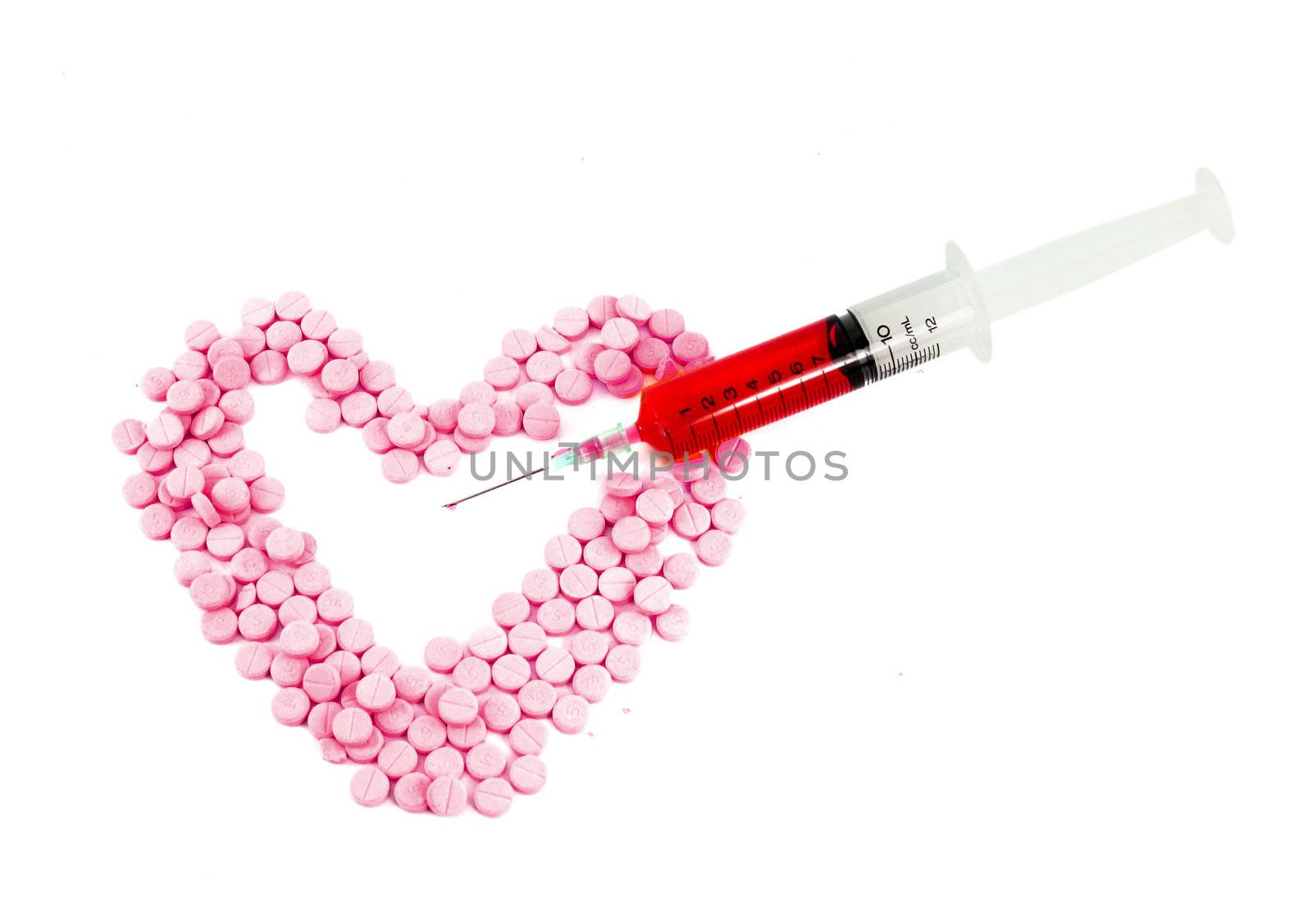 Syringe and pink pills form heart shape isolated on white backgr by geargodz