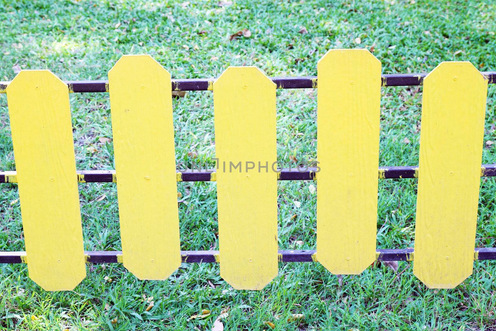 yellow wooden fence on a green meadow by geargodz