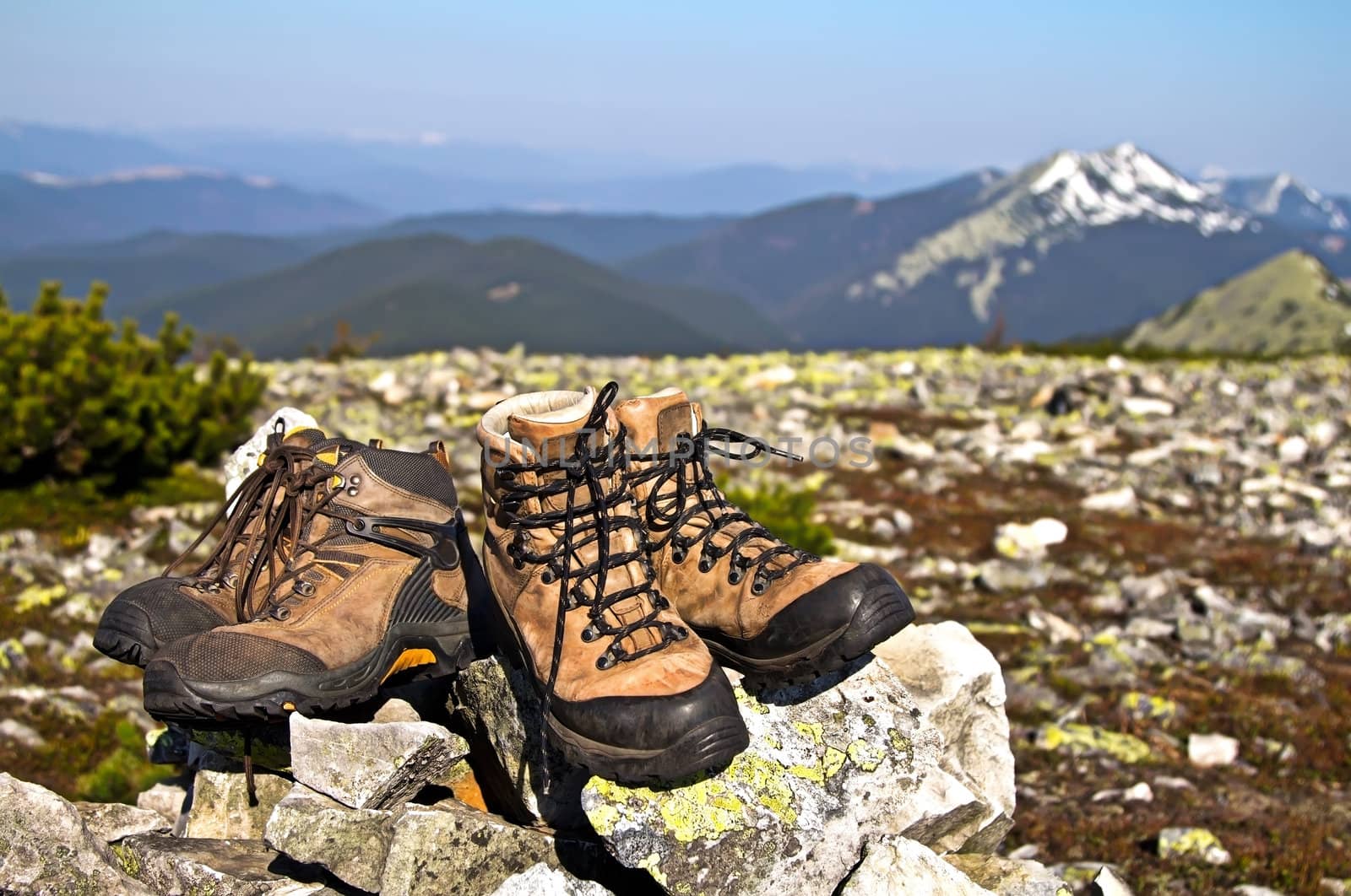 Old boots against of mountain landscape by marinakhlybova