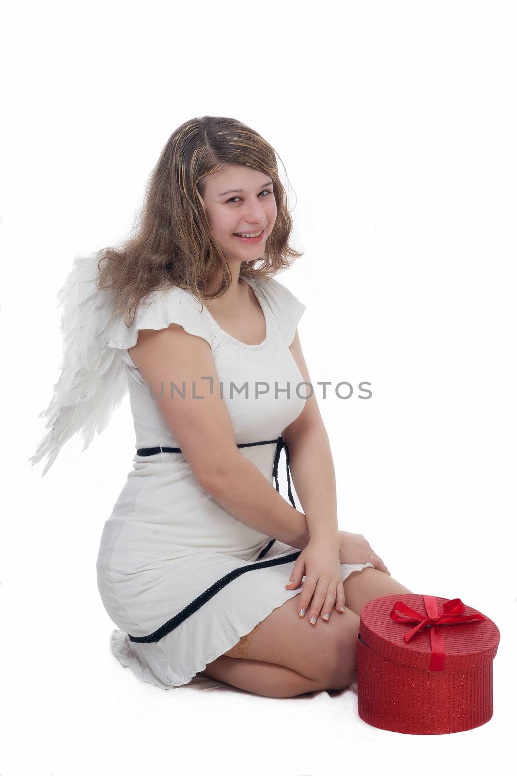 smiling christmas angel with golden hair on white background with wings and a gift 