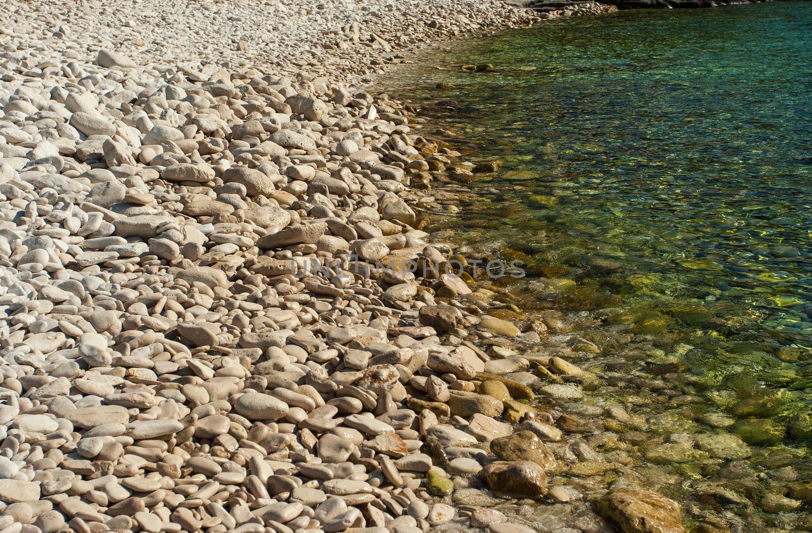 White stony beach in Croatia wiht sunshine