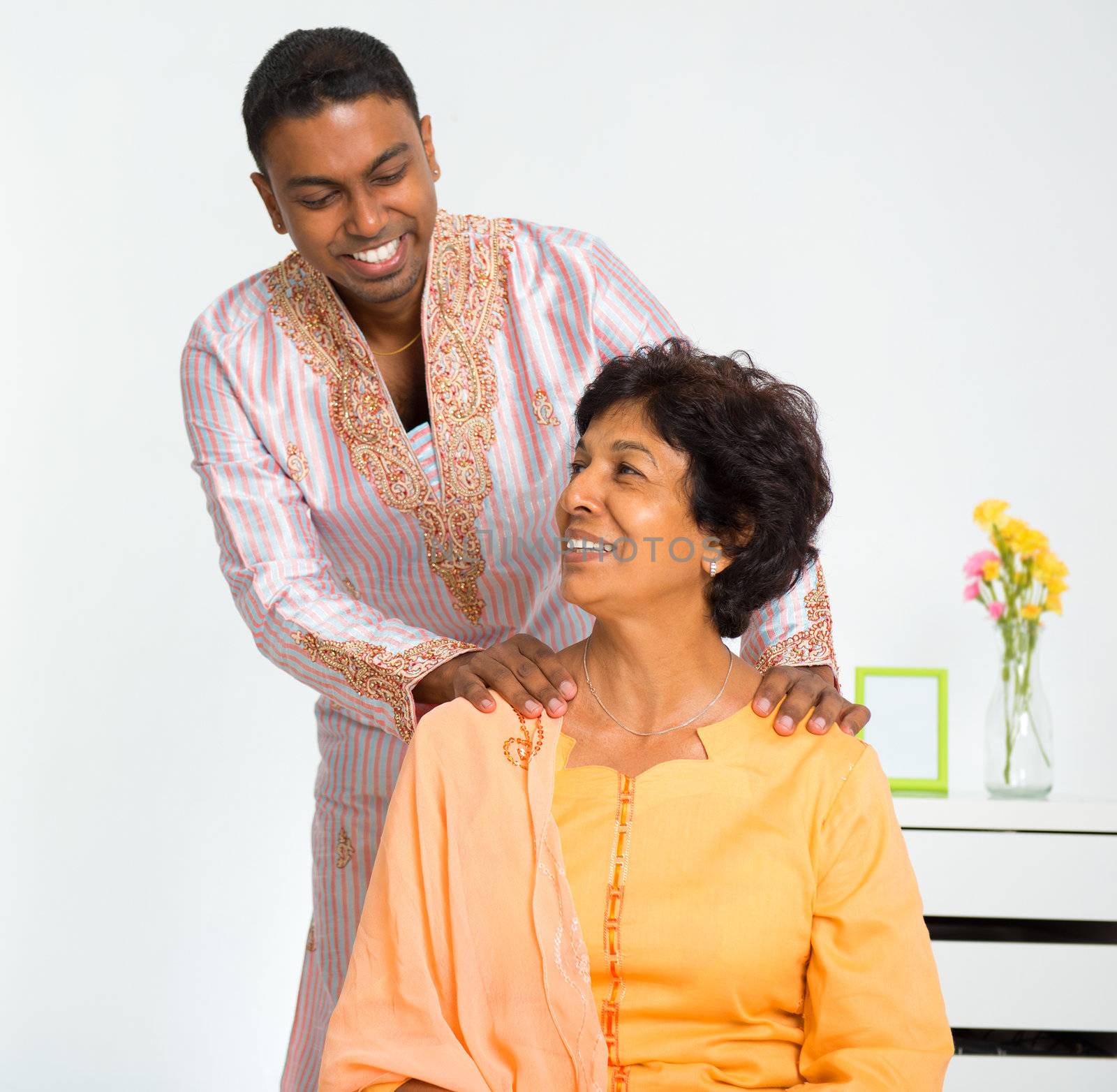 A lovely mature Indian woman enjoying a shoulder massage from her son at home