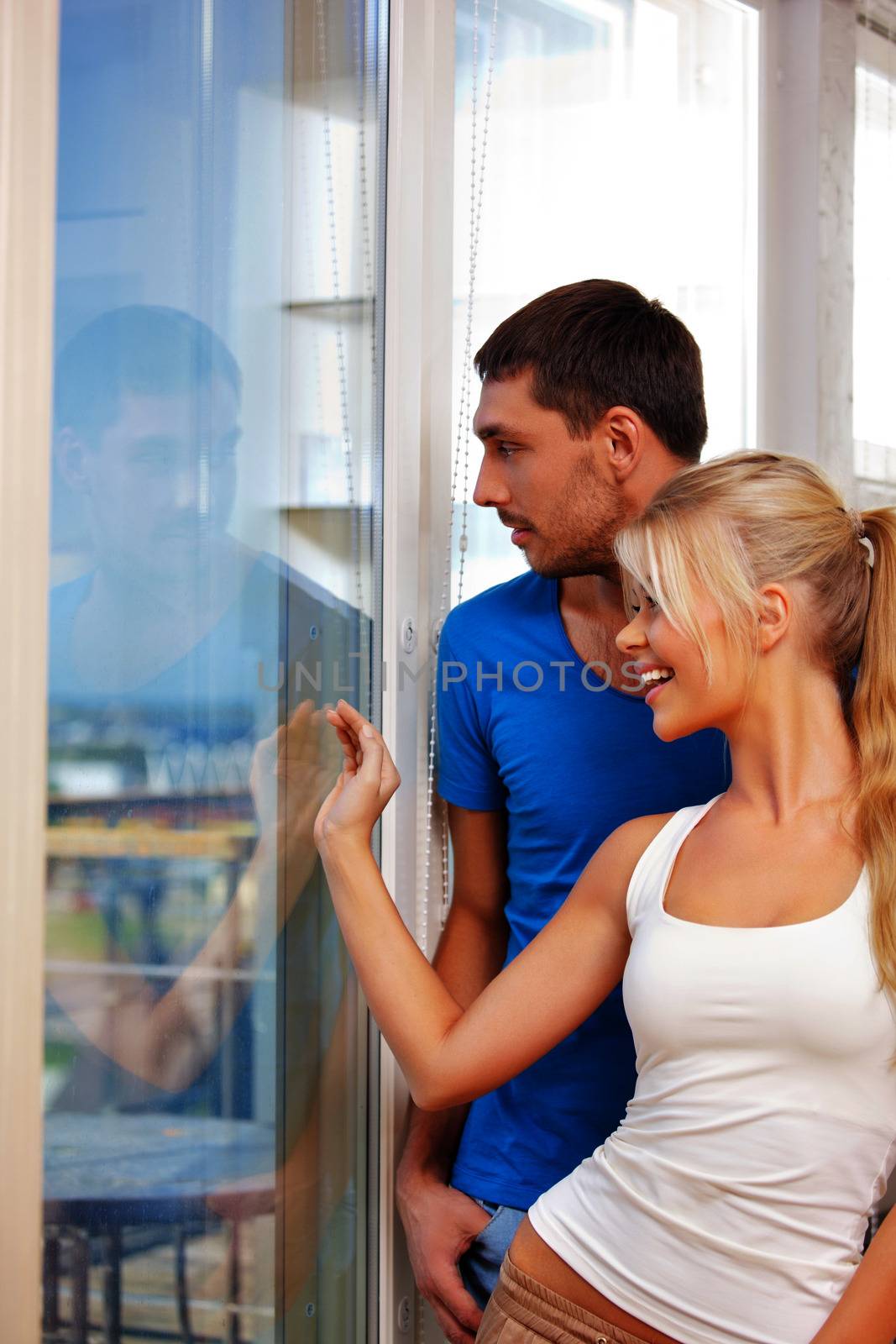 bright picture of happy couple at the window (focus on man)