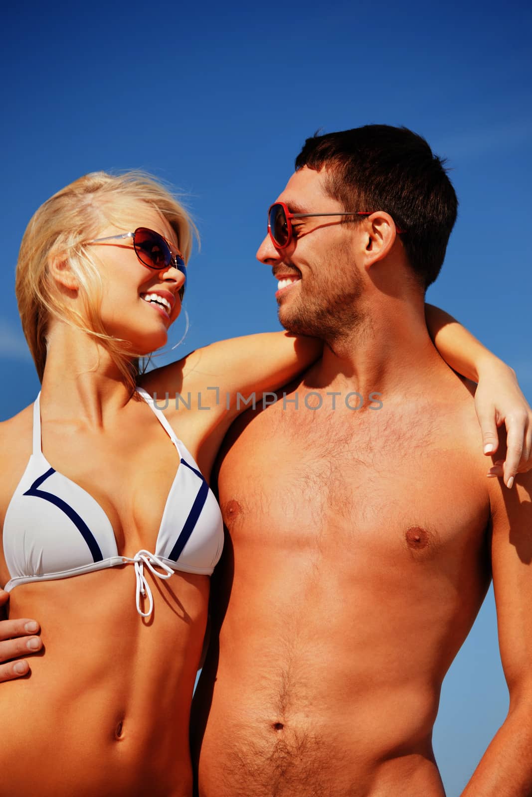 picture of happy couple in sunglasses on the beach.