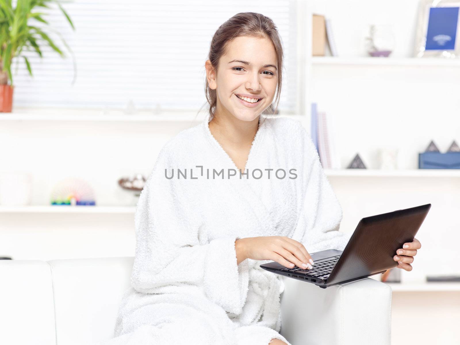 Woman in bathrobe with computer by imarin
