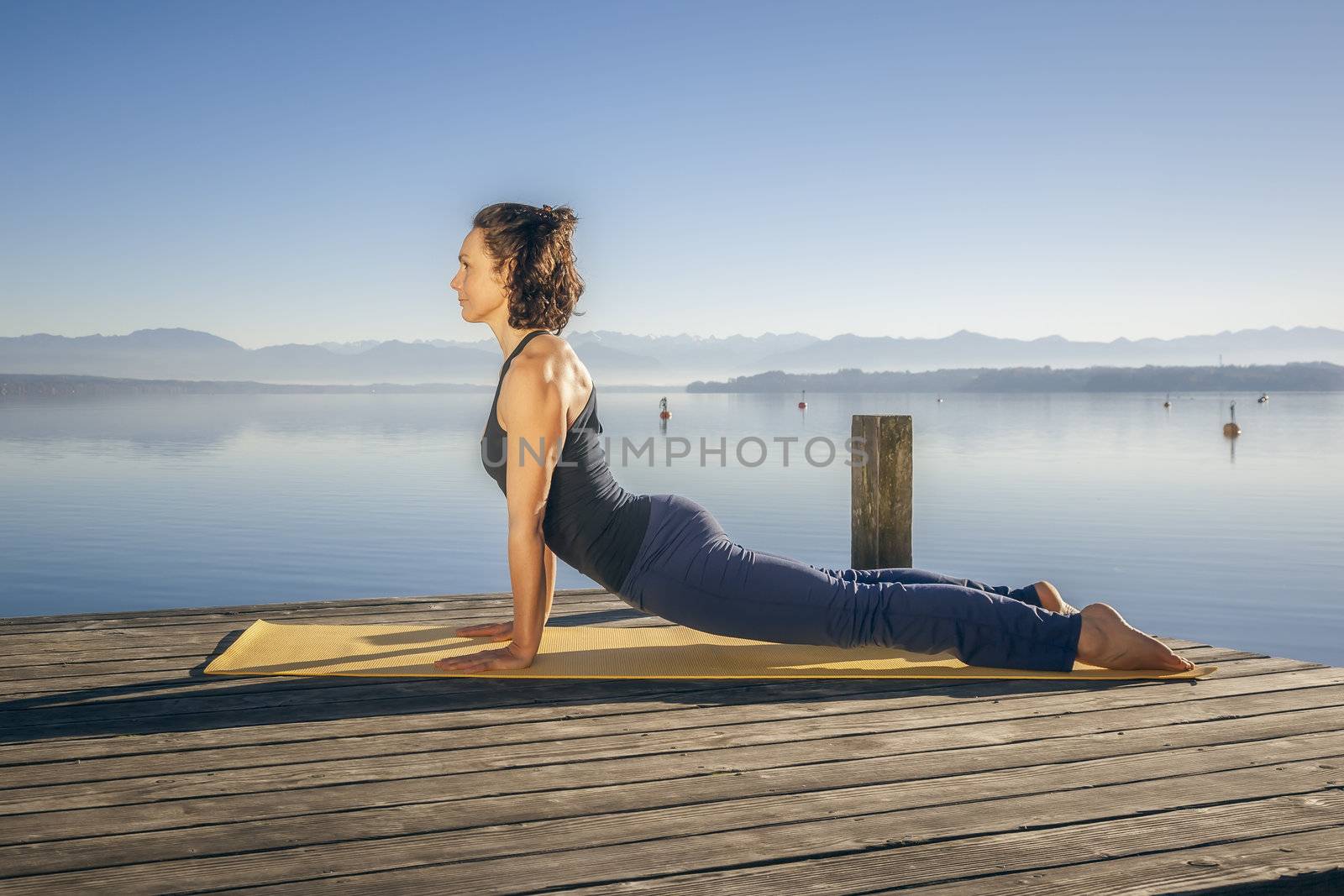 An image of a pretty woman doing yoga at the lake