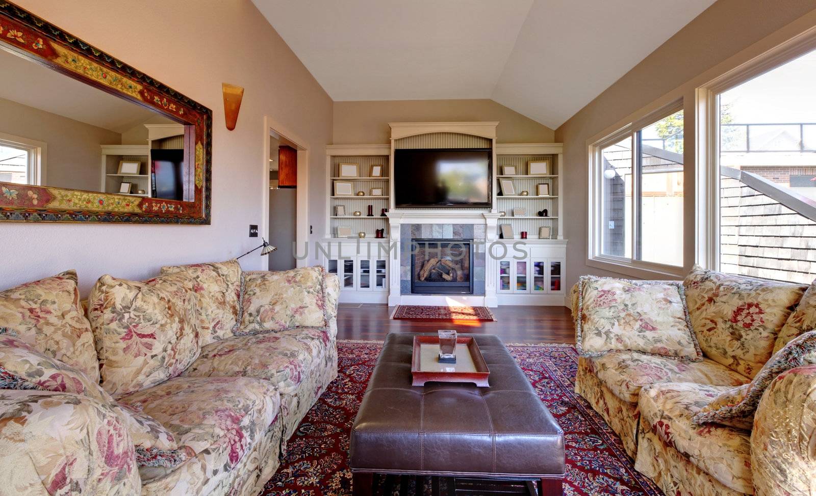 Large living room with sofa, TV and brown walls with beige carpet.