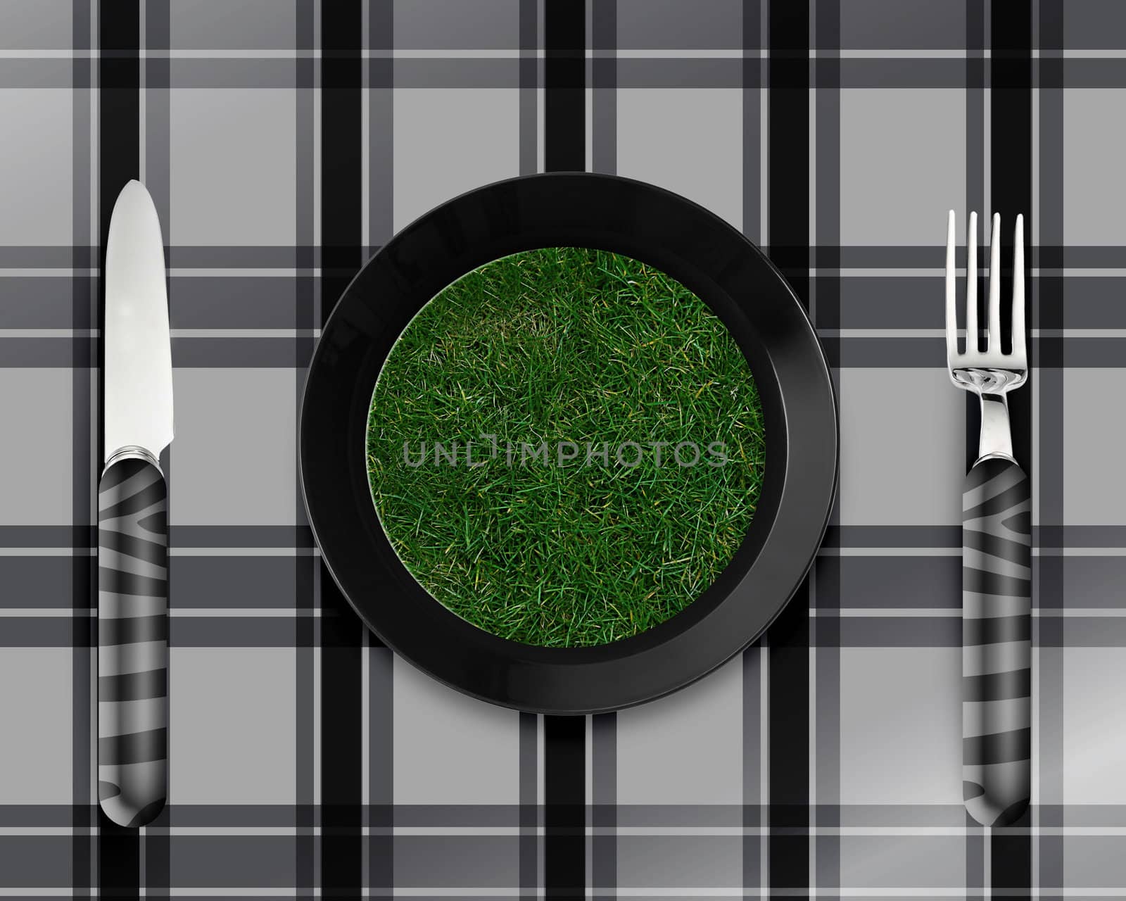 green grass on black plate with knife and fork.