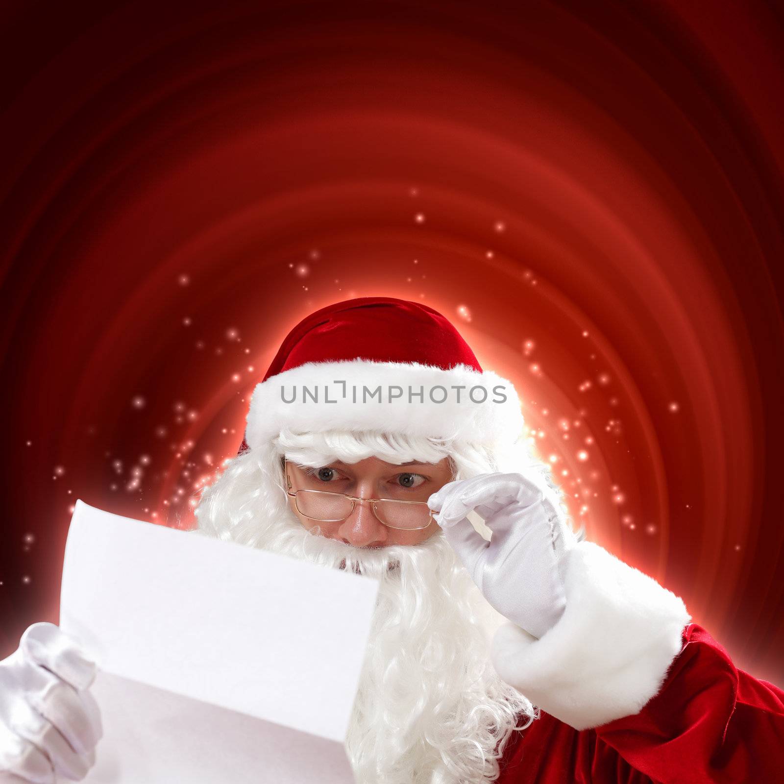 Santa holding Christmas letters and looking at camera