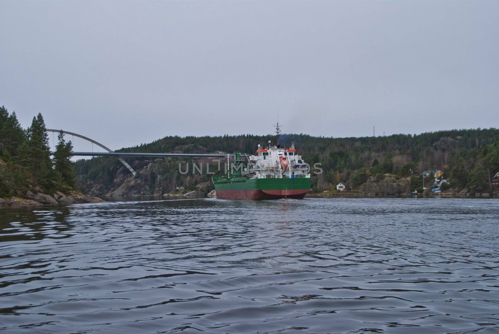 the cargo ship "sunnanhav" sailing under svinesund bridge on the way out of ringdalsfjord and to open sea, the ship has discharged its cargo in the port of halden, image is shot in november 2012 under svinesund bridge, some facts about the ship: ship type: cargo, length x breadth: 114 m X 16 m, gross tonnage: 5325, deadweight: 9402 t, flag: faroe is [fo]