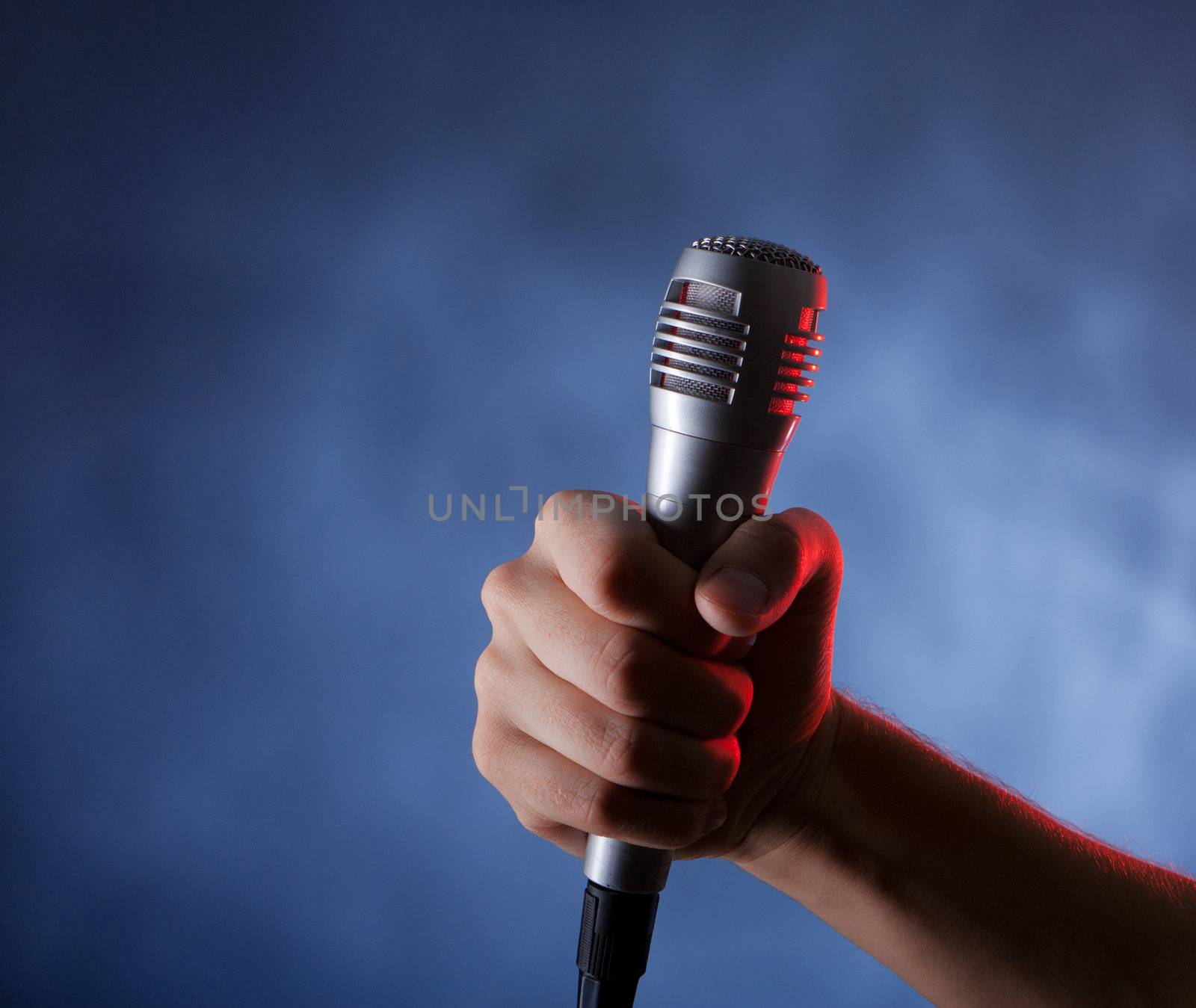 microphone in hand on the dark background