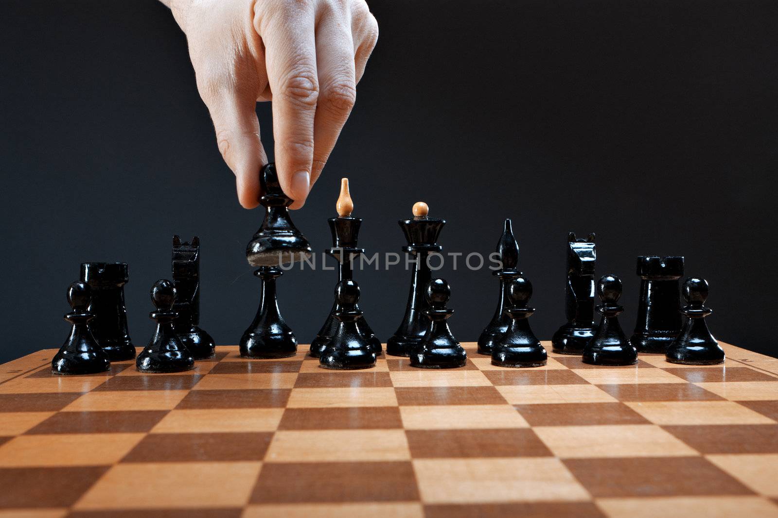 hand moves chess pawn on a dark background