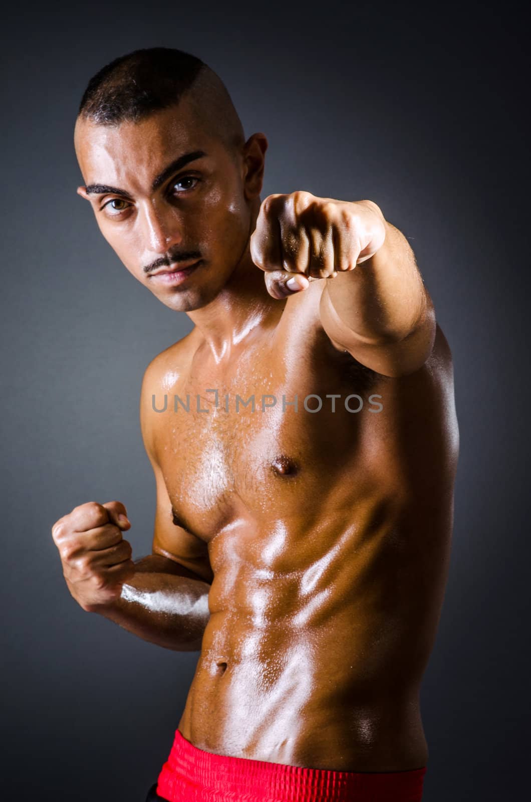 Muscular boxer in dark studio by Elnur